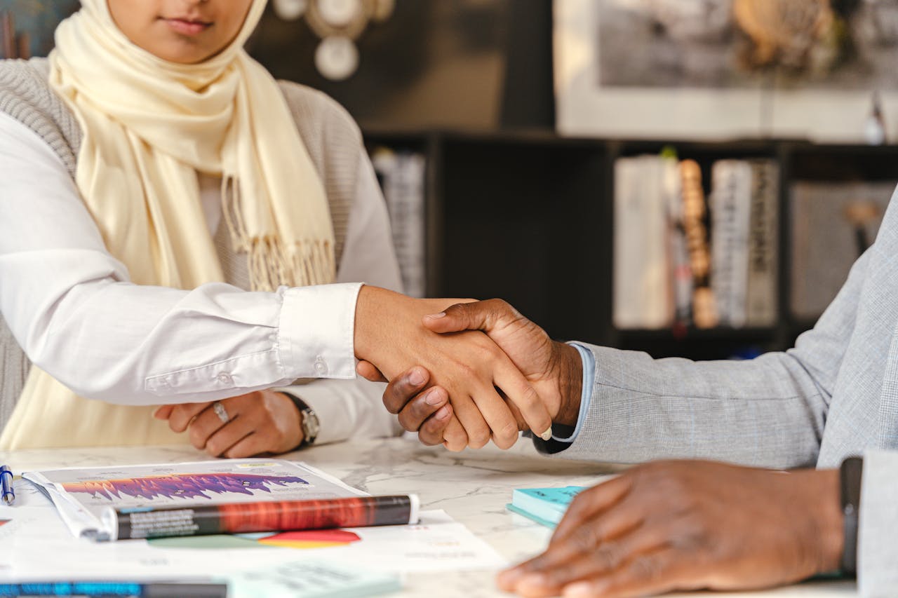 Close-up of business professionals shaking hands in an office setting.